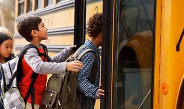 Niños subiendo al autobús escolar
